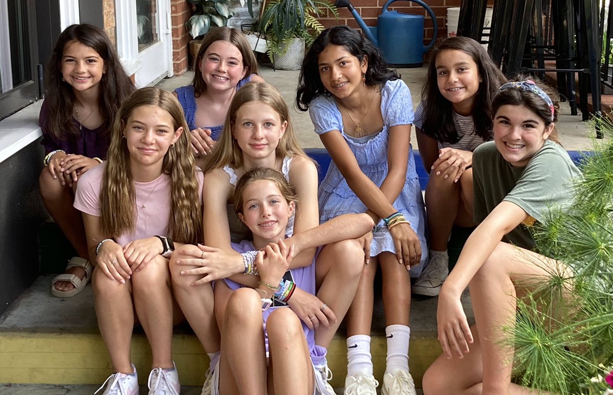 Block Image: Group of students sitting on the steps of a porch smiling